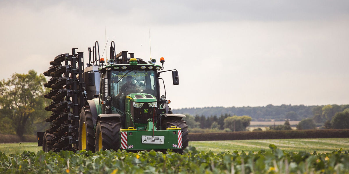 Green John Deere tractor with black and yellow attachments at Walcot Lodge Farm