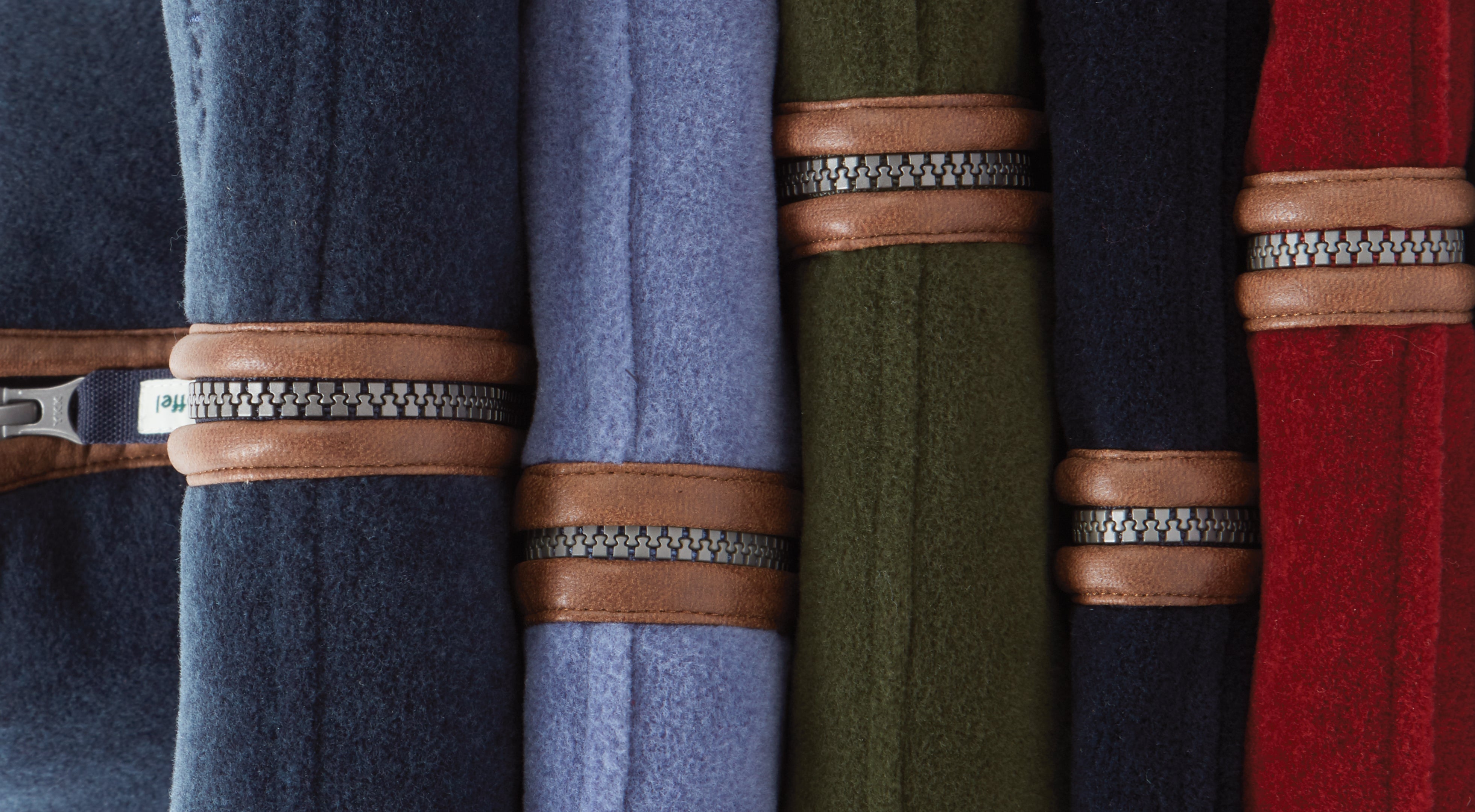 Rolled wool scarves in navy, blue, olive, black, red with tan leather straps