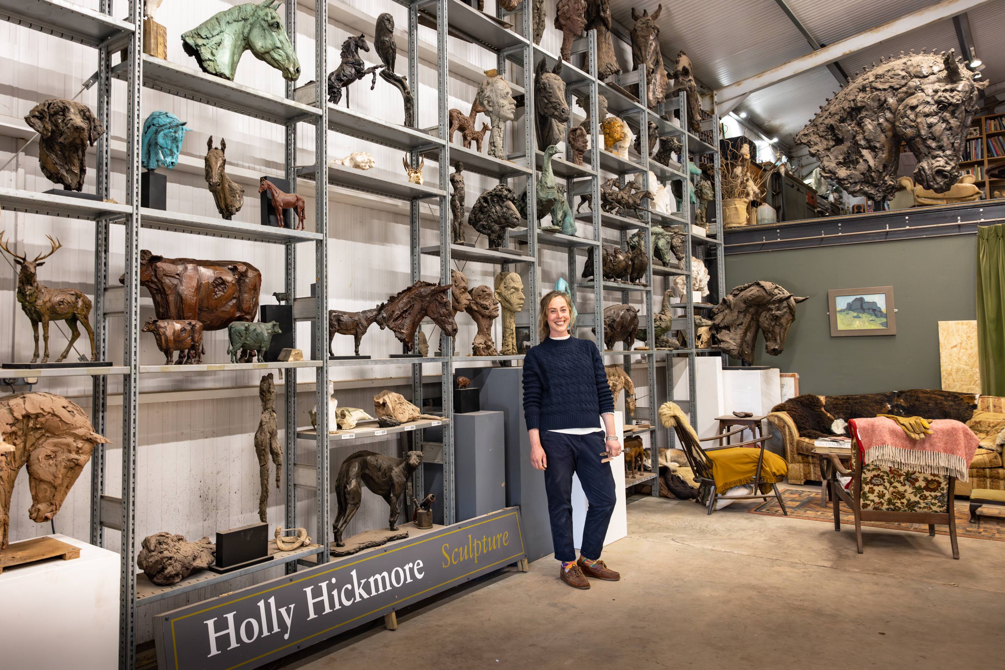 Sculptor Holly Hickmore in studio with bronze and wood animal sculptures