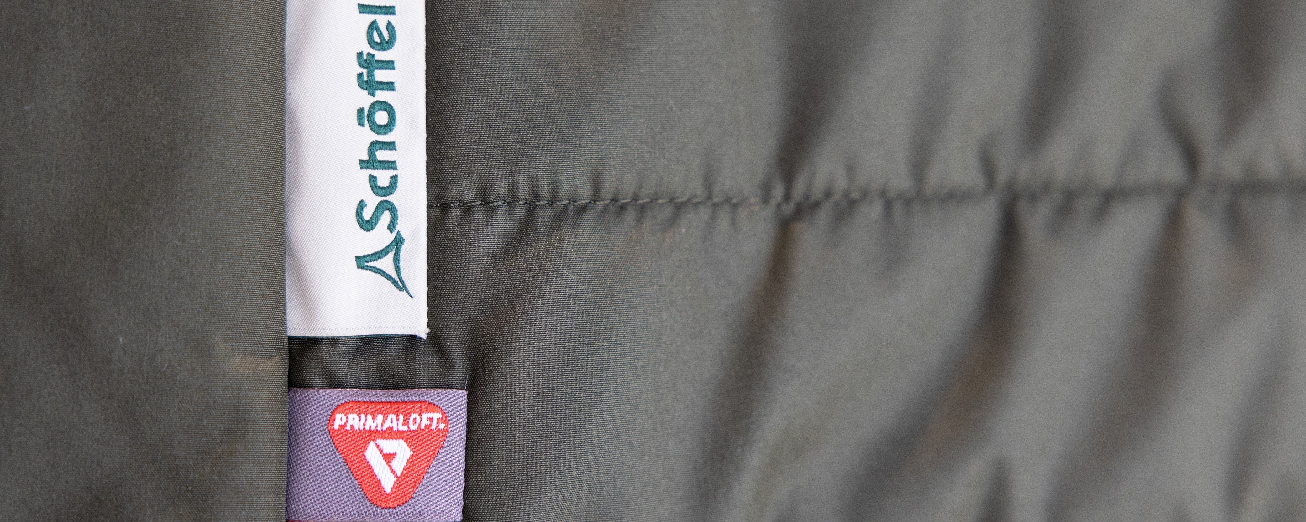 Gray quilted jacket with Schoffel tag and PrimaLoft insulation label