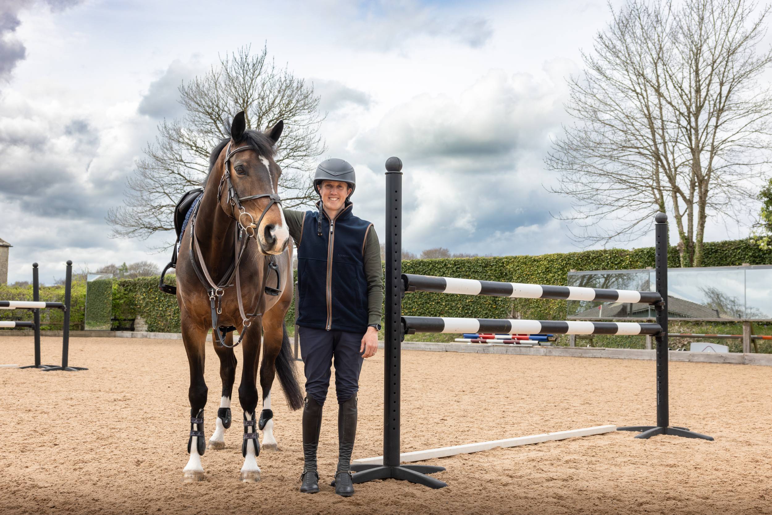 Tom McEwens dark brown horse with glossy coat and white socks in arena
