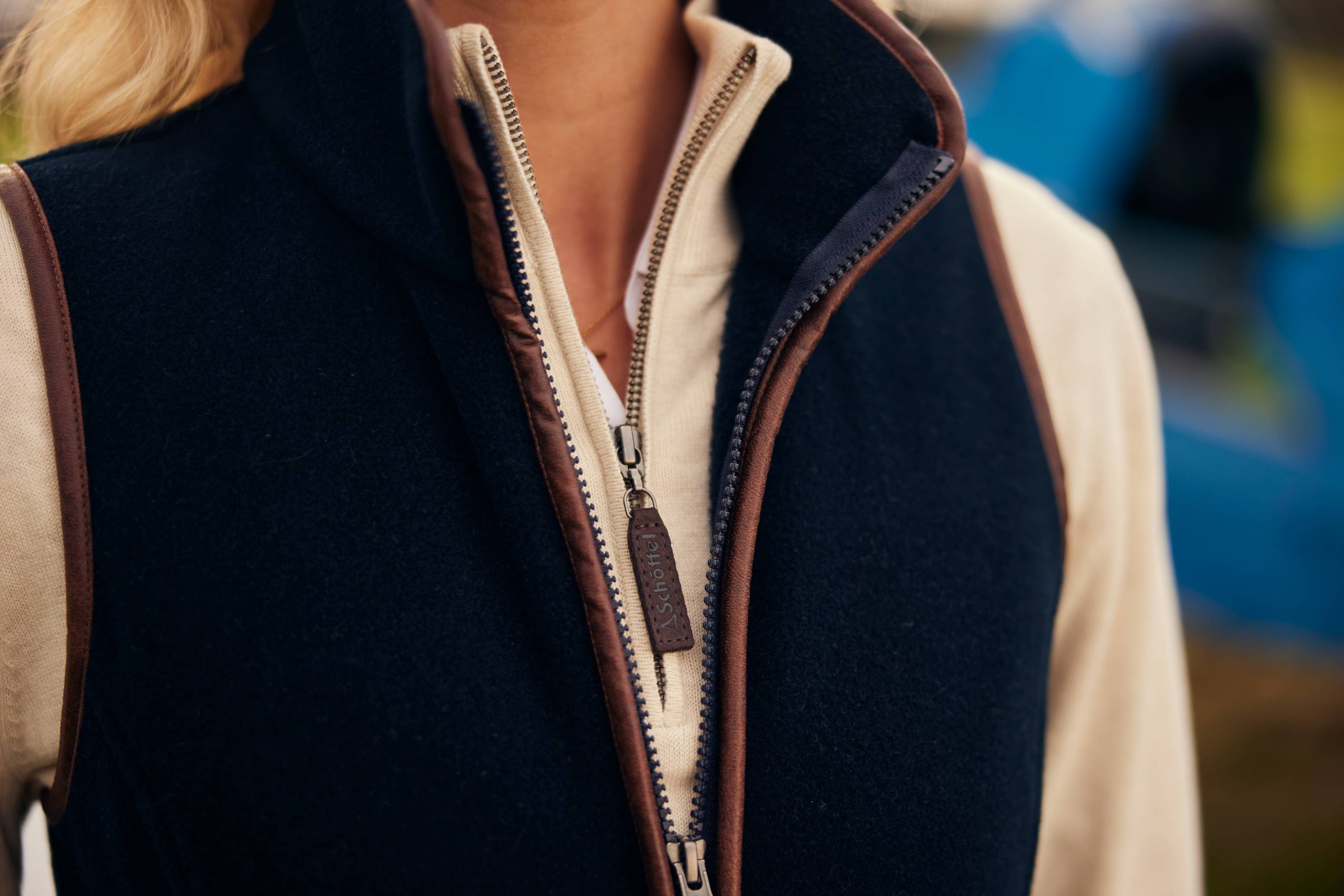 Navy blue fleece vest with cream lining and brown leather trim