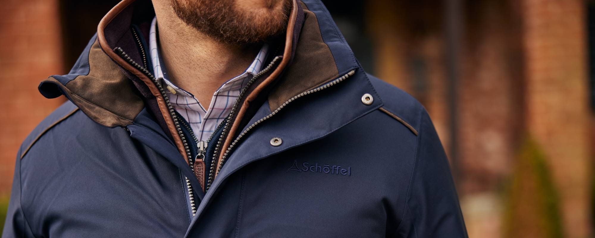 Navy blue insulated jacket with brown leather trim in Venturi tech article