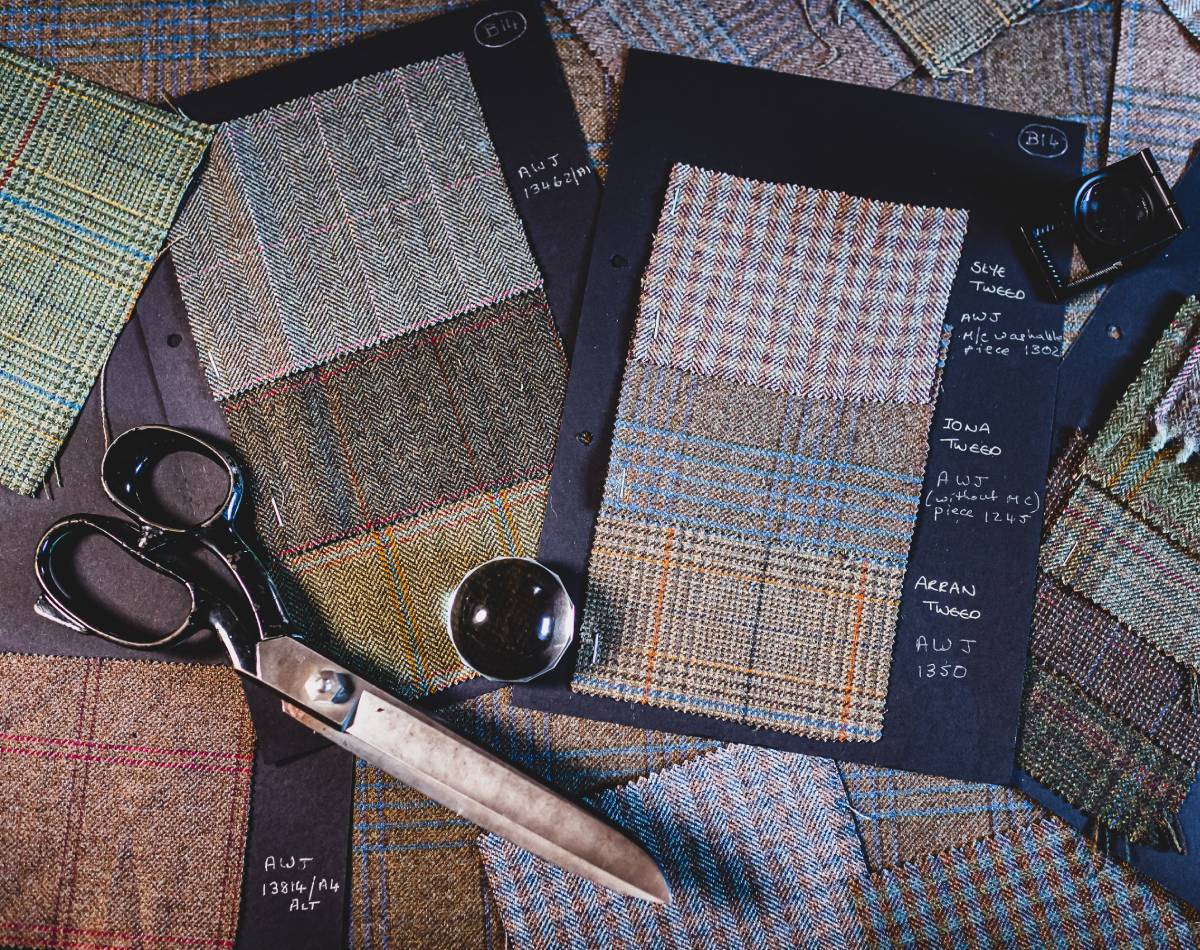 Tweed fabric swatches in earthy tones and herringbone patterns with scissors