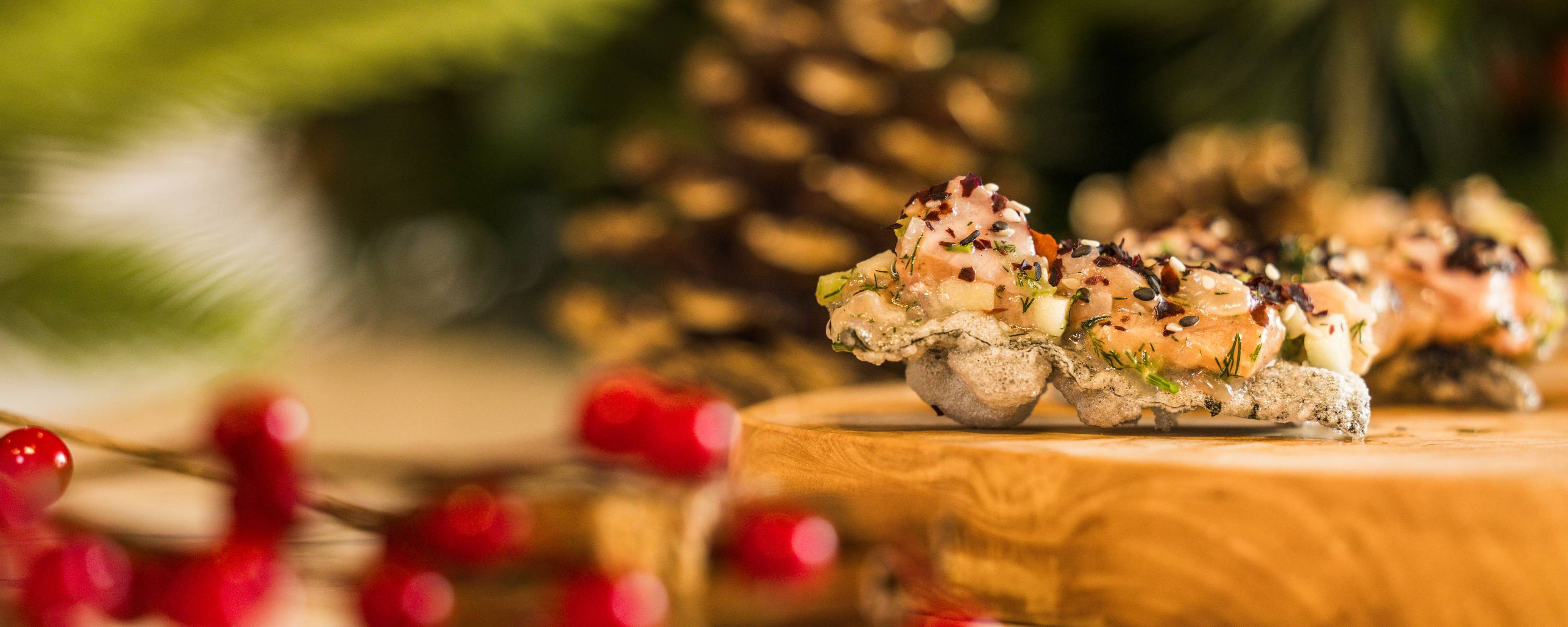 Delicate bite-sized seafood appetizers on rustic board in Alfie Sanderson interview