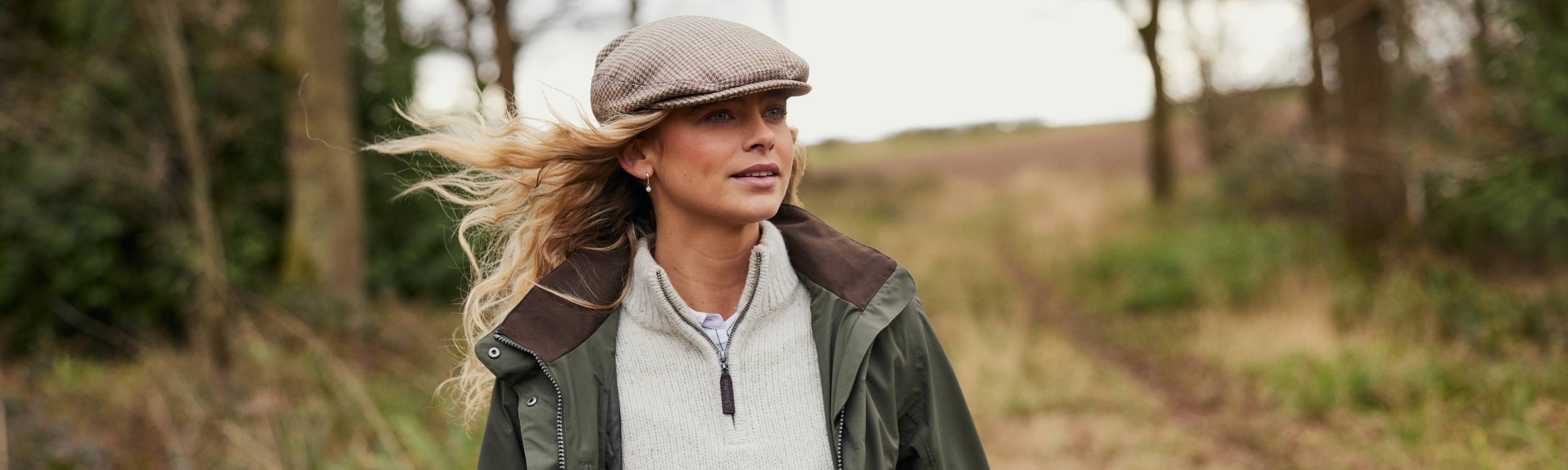 Woman in tweed flat cap with earth-toned knit pattern and leather trim