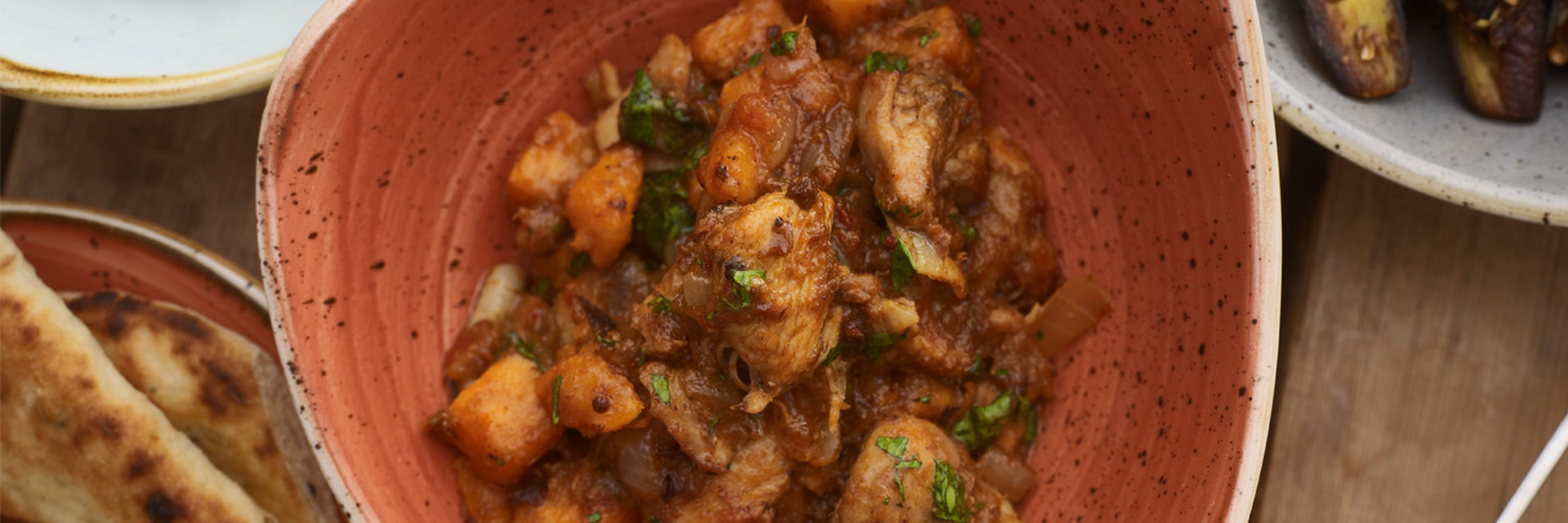 Rustic terracotta bowl of chicken sweet potato stew from Game-to-Eat partridge recipes