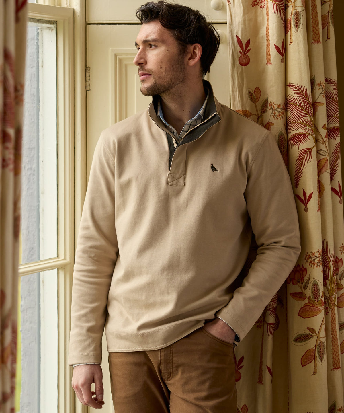 Beige Branscombe Cove quarter-zip sweater with gray inner collar and black bird logo