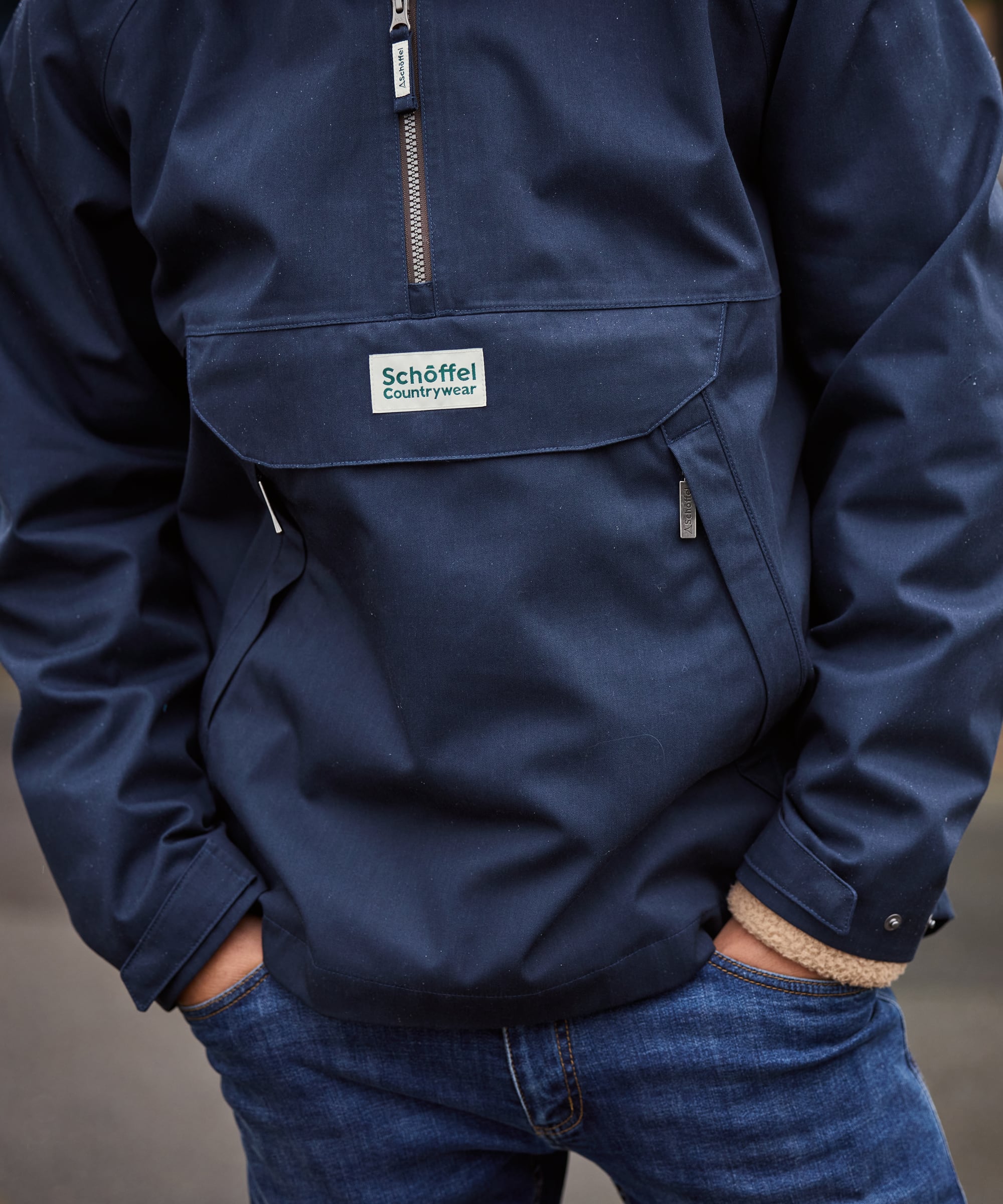 Navy blue jacket with a visible brand logo on the chest pocket against a neutral background