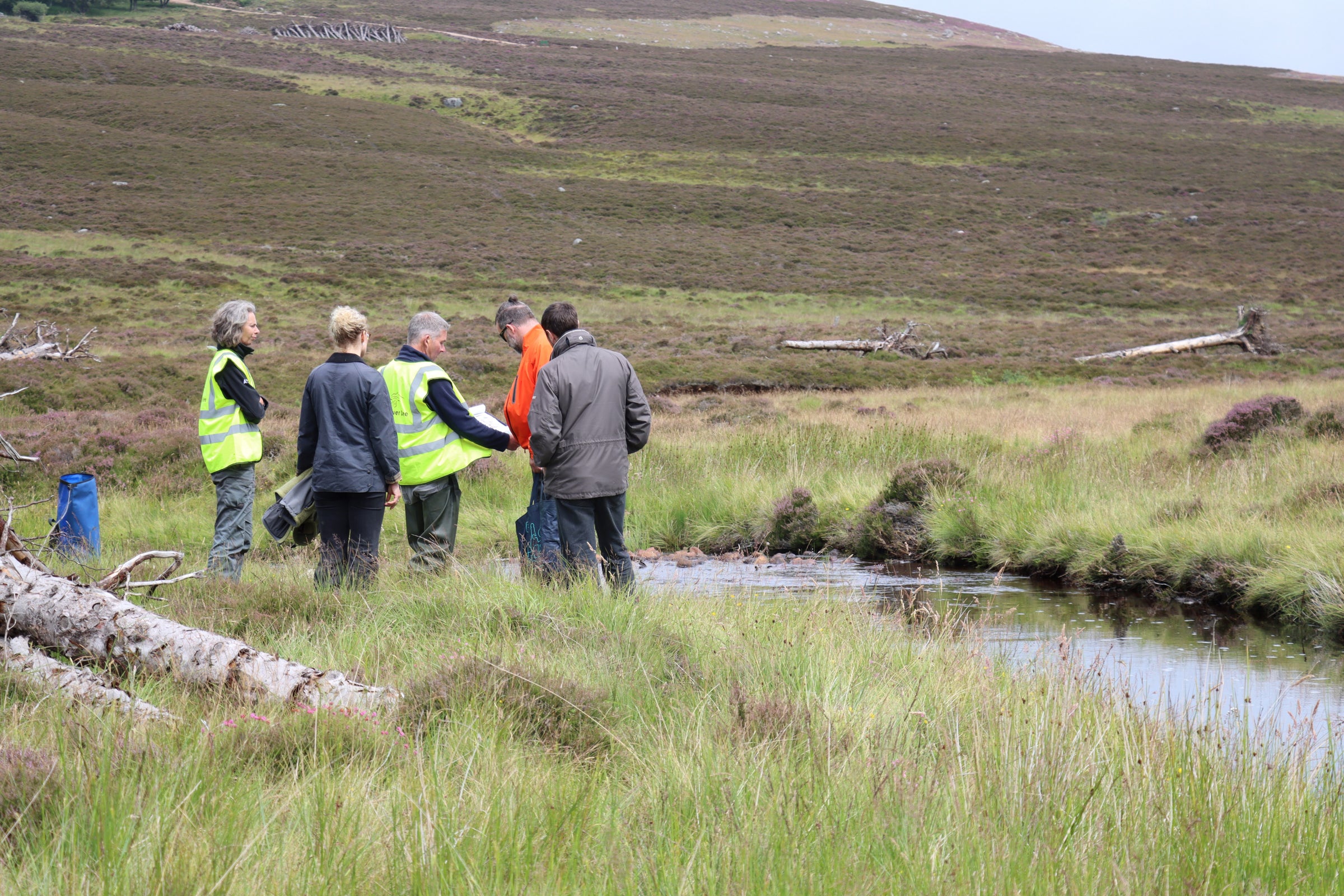 A group of people standing by a river.