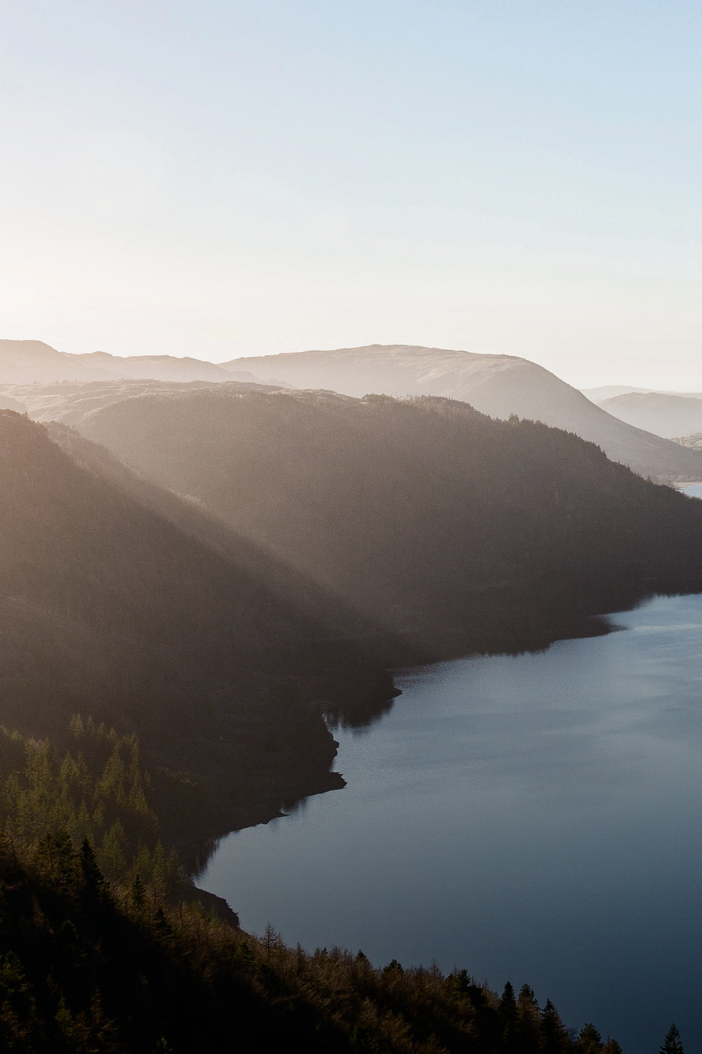 Lake surrounded by mountains with a clear sky