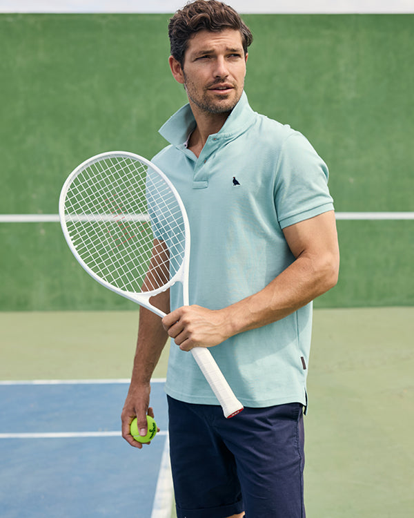 Man holding a tennis racket and ball on a tennis court