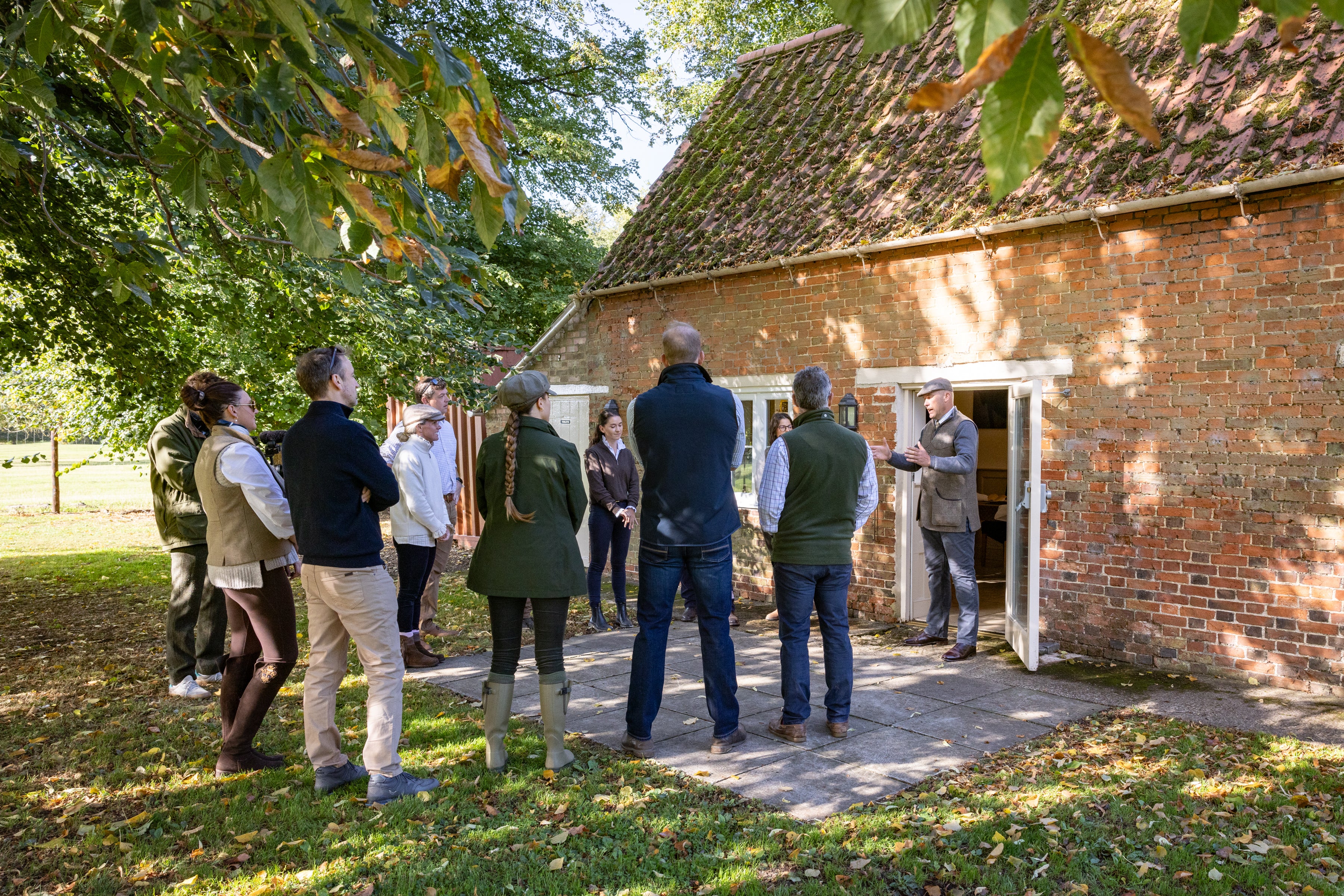 Group of people standing outside a rustic building in a natural setting