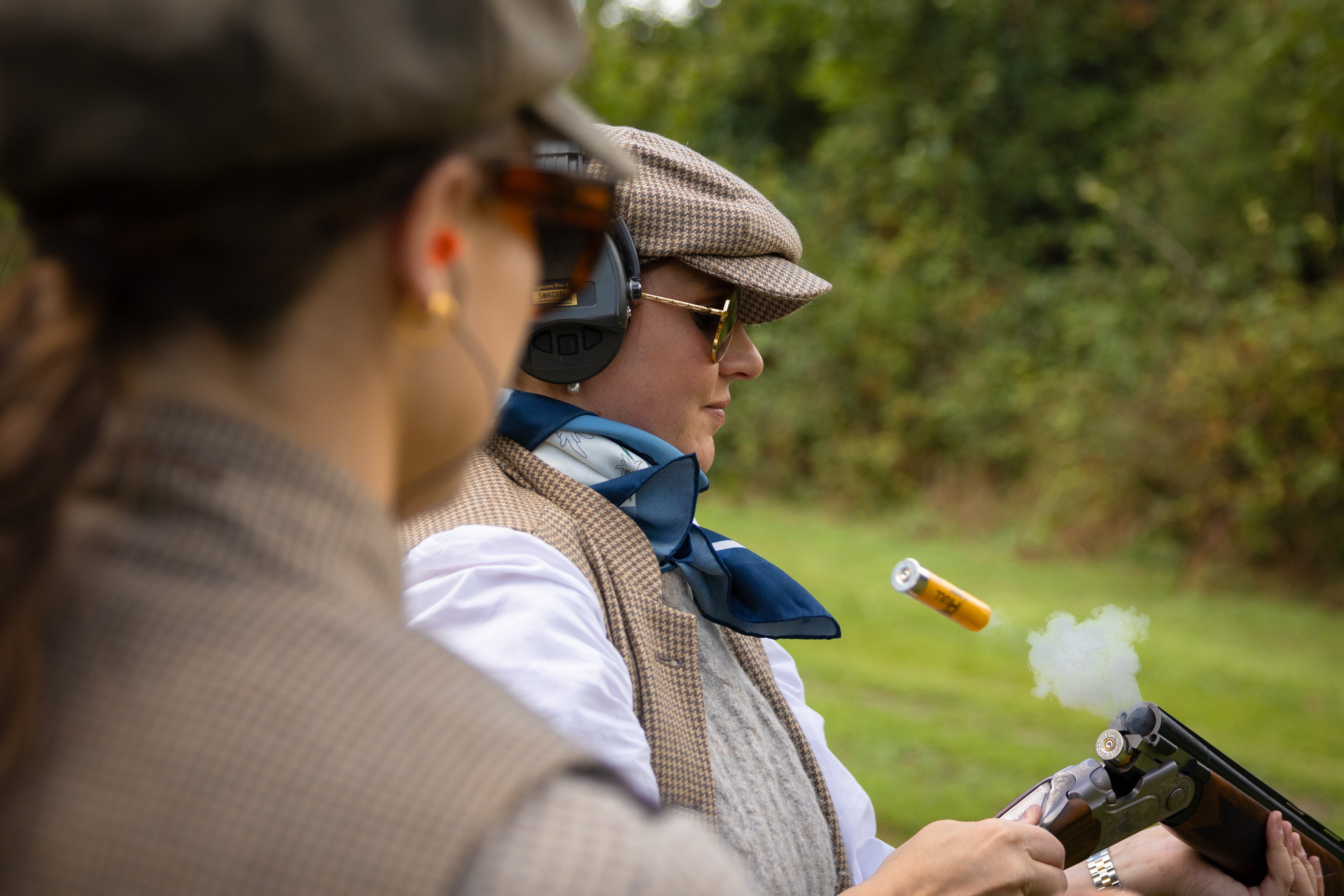 Person in vintage attire with a rifle, outdoors