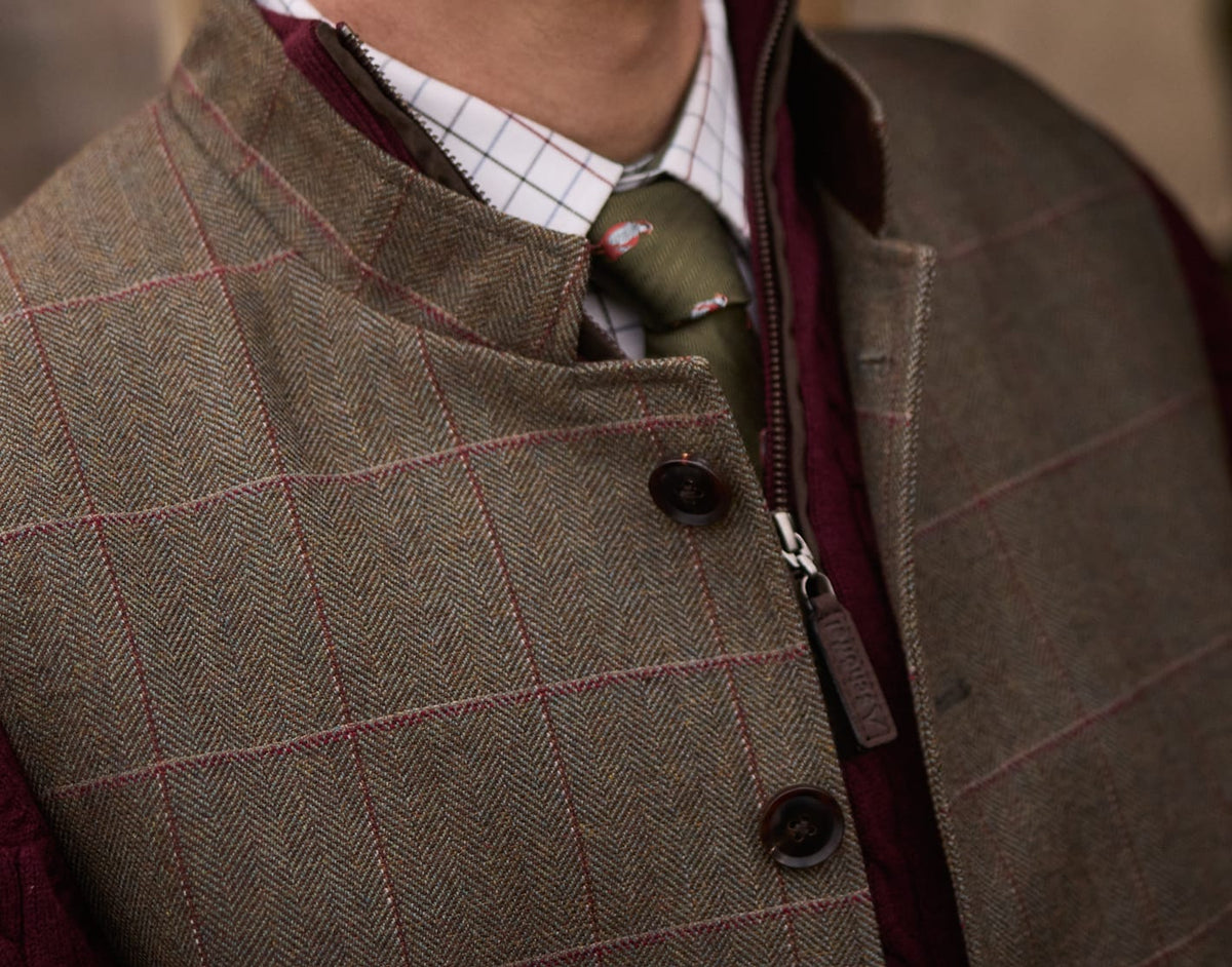 Close-up of a person wearing a brown tweed waistcoat