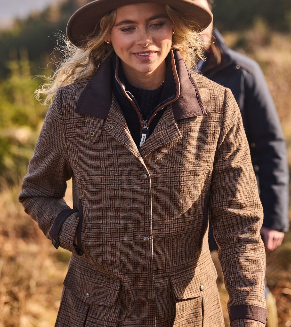 Woman wearing a brown tweed coat in an outdoor setting