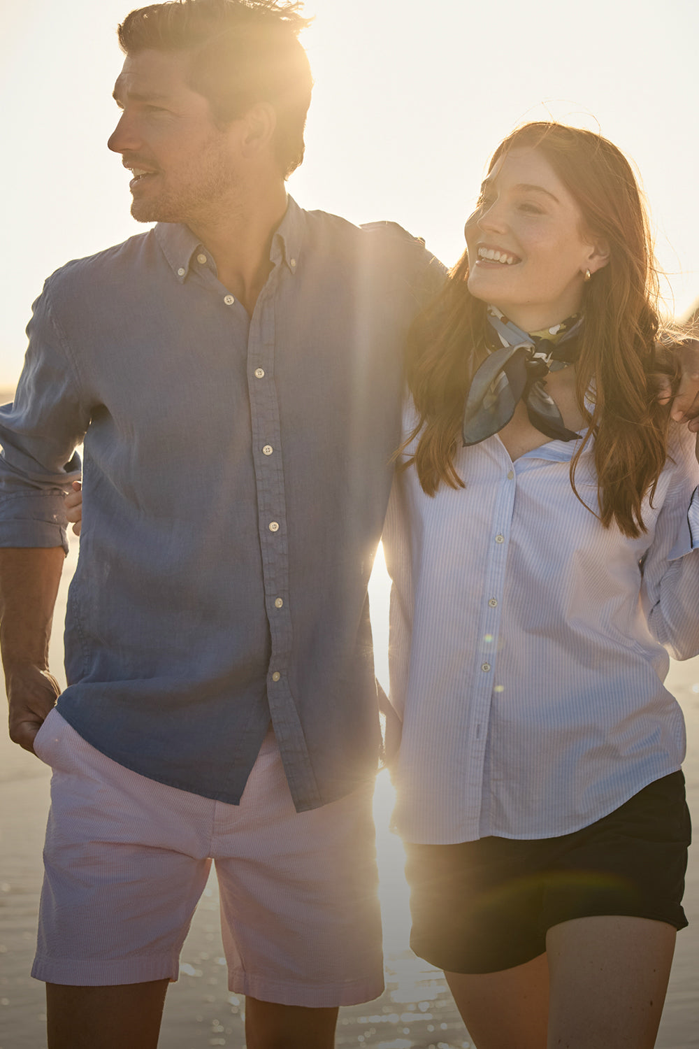 Man and woman walking together on a beach at sunset