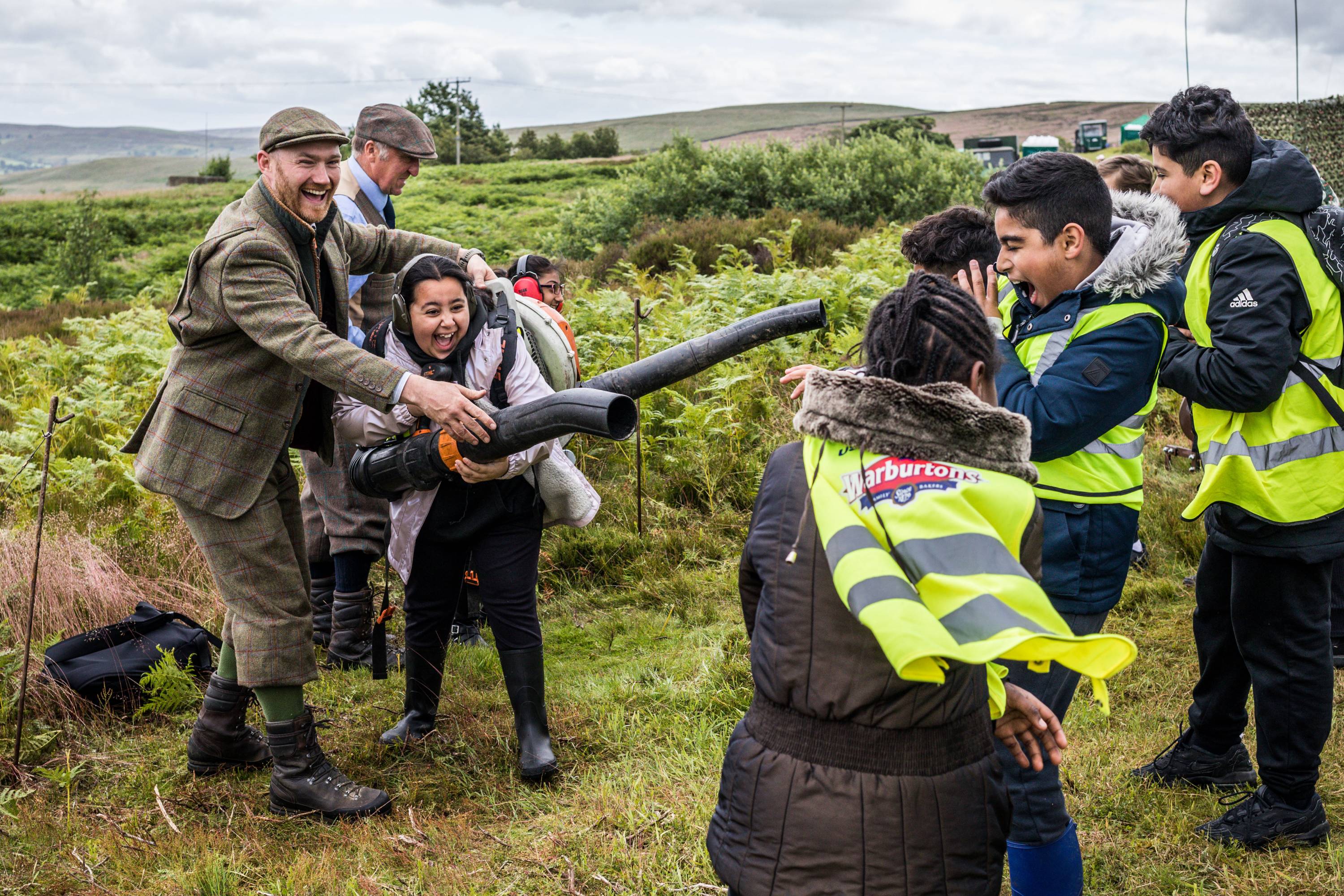 A group of people standing in a field laughing.