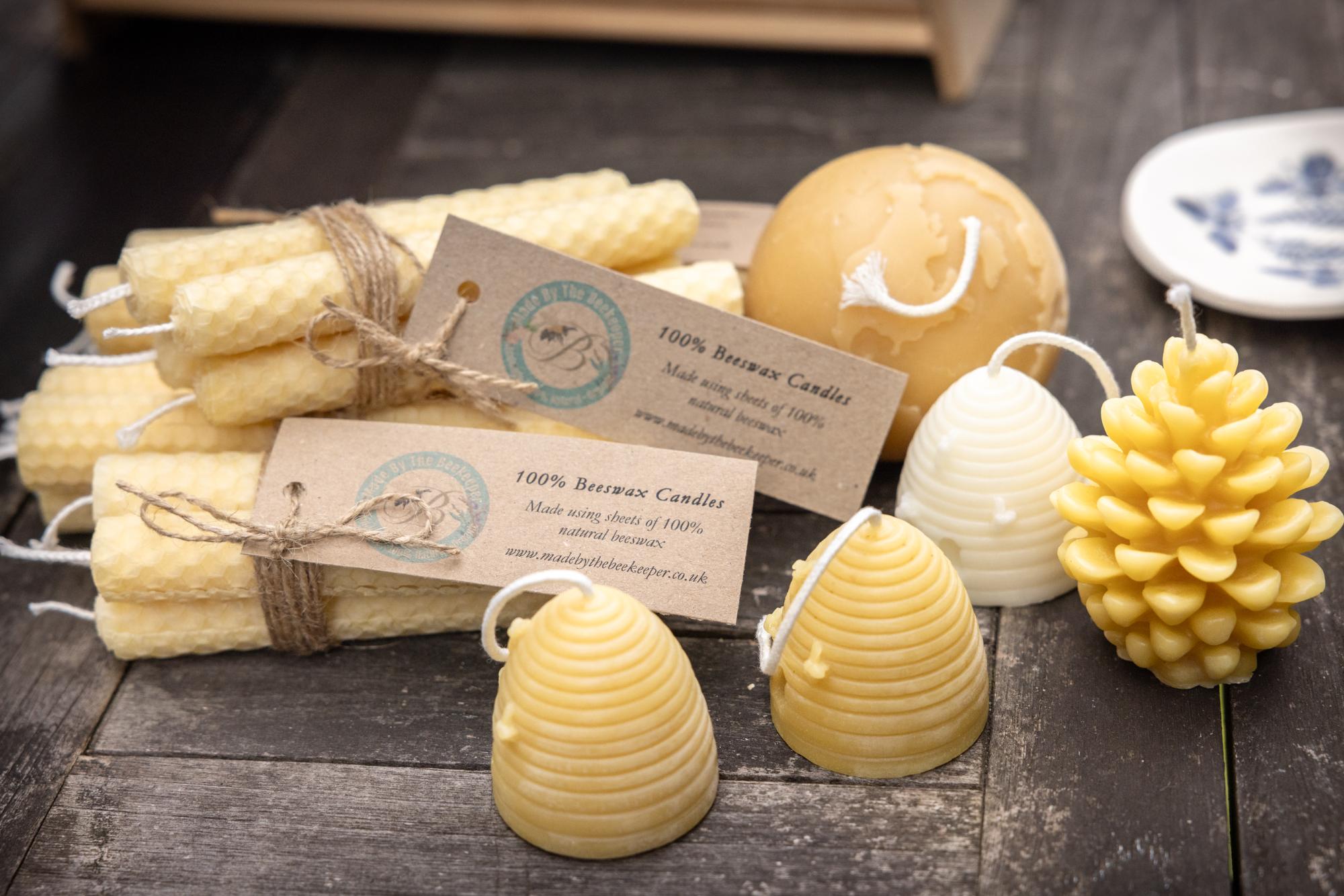 Beeswax candles laid out on a rustic table.