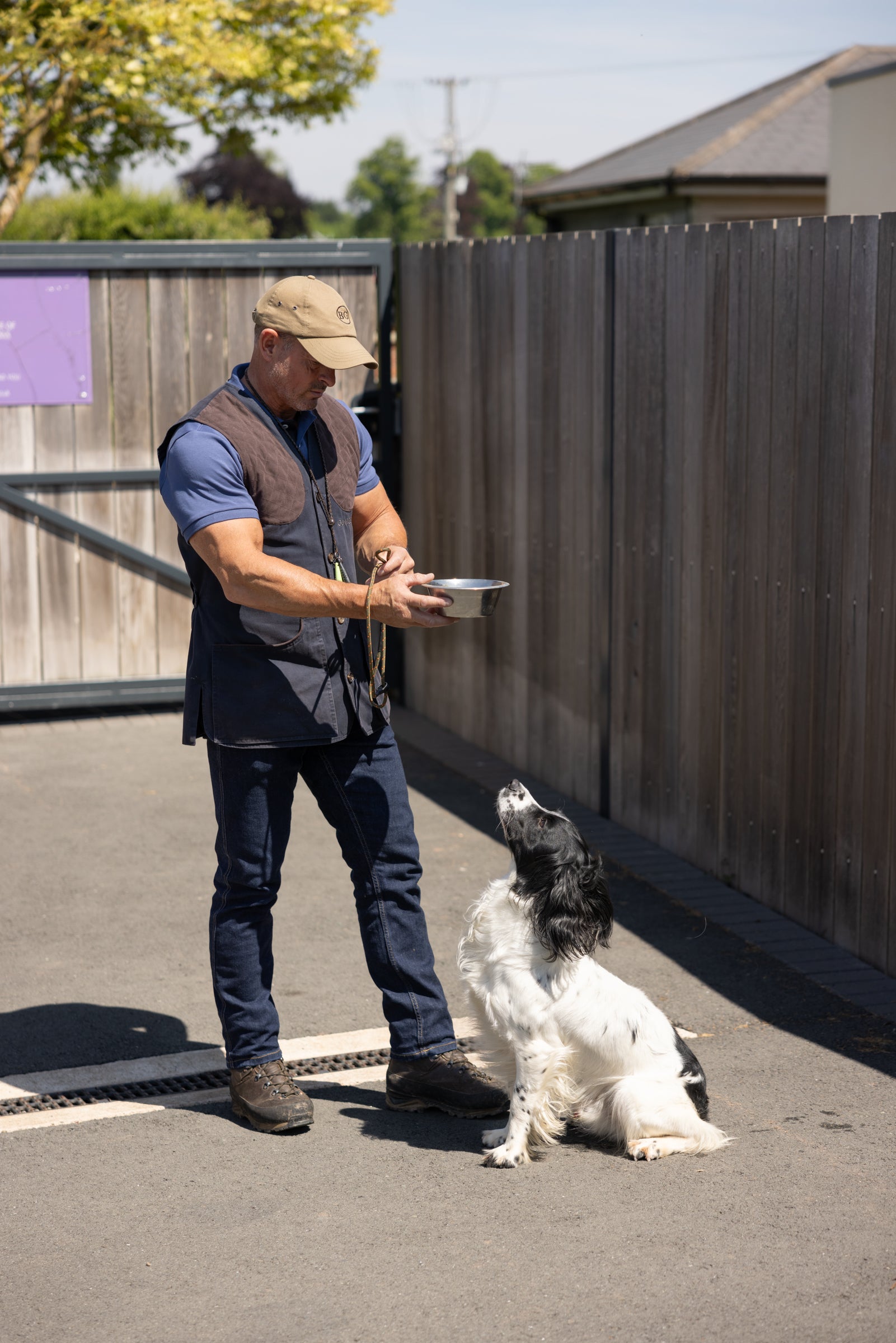 Man standing with a dog on a leash in an outdoor setting