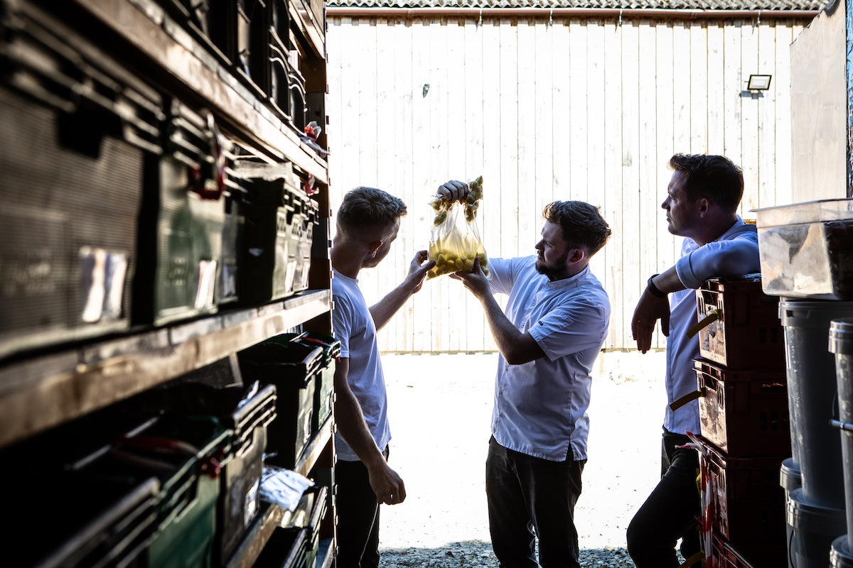 A group of men standing in a warehouse.