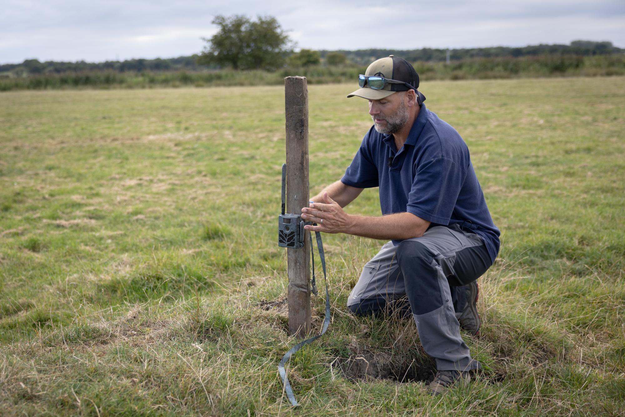 Man working with a post in a field