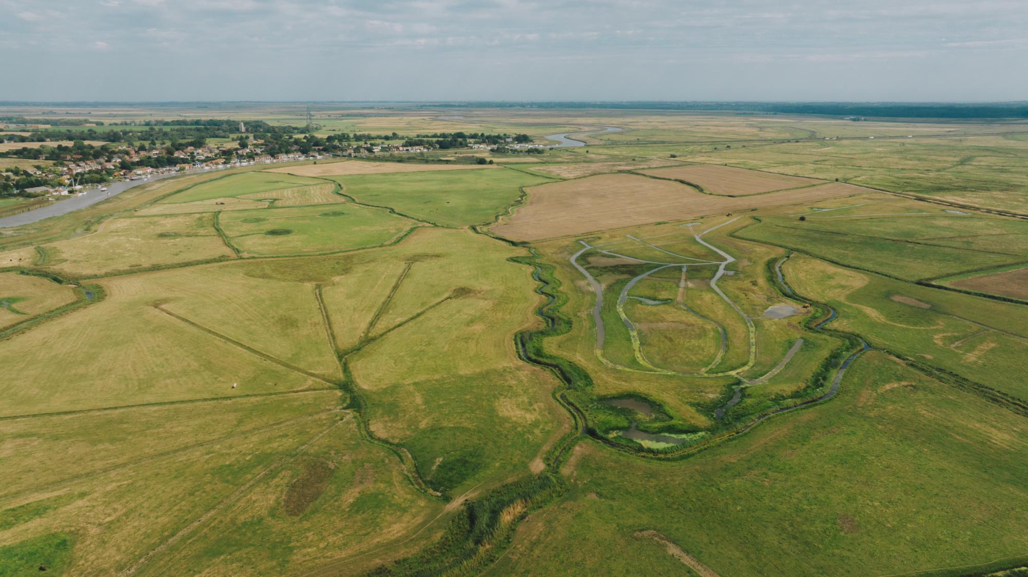 Aerial view of a rural landscape with fields and a river.