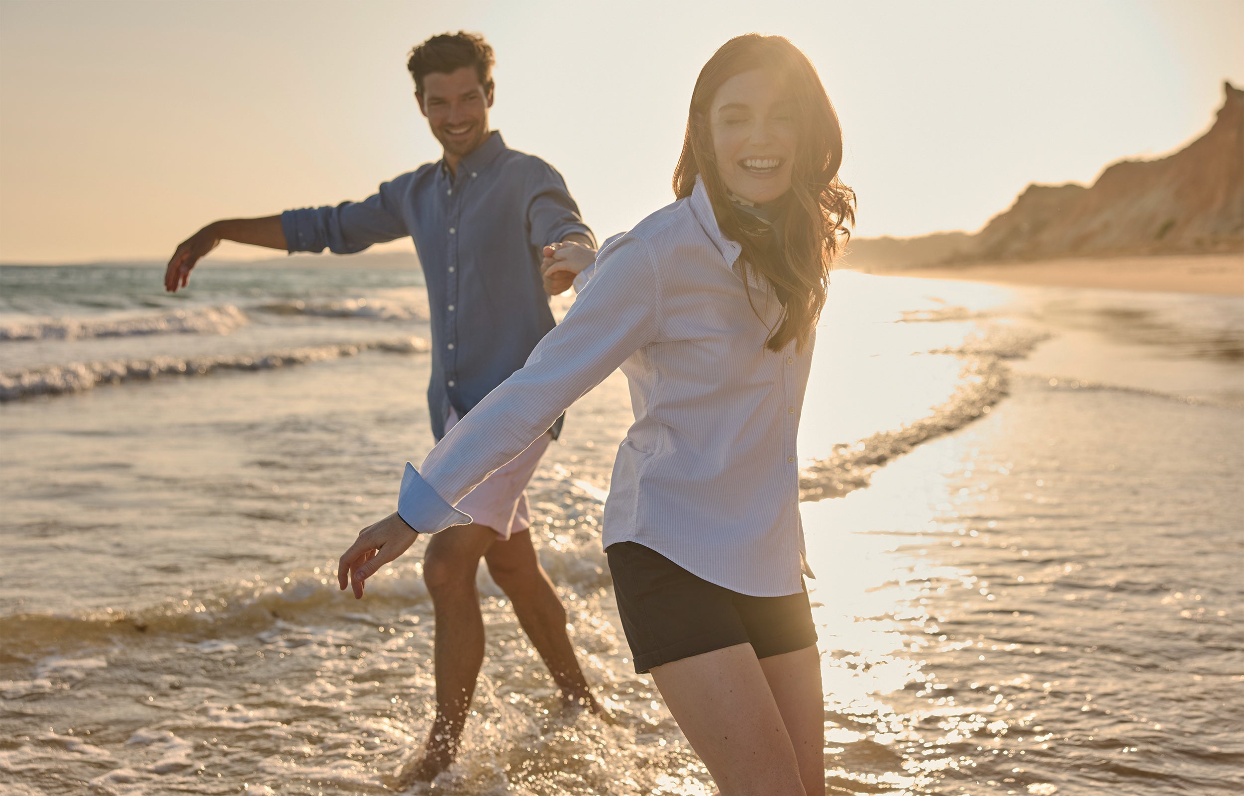 Man and woman walking on a beach at sunset
