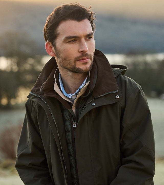 Man wearing forest green waterproof country coat with a dark brown suede collar and zip-in fleece