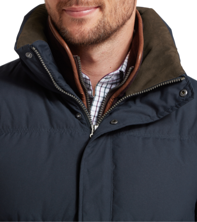 Navy blue jacket with brown hood and plaid shirt underneath on a white background