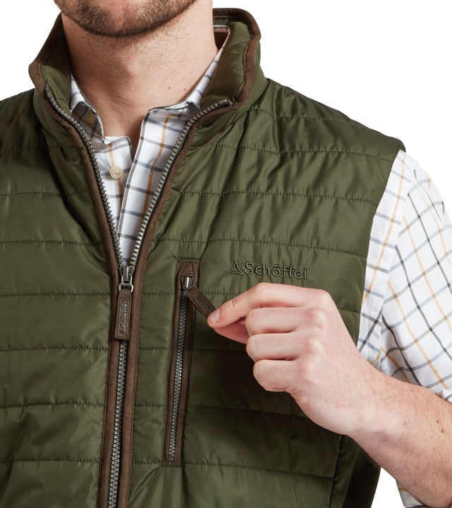 Model wearing the Schöffel Brora Gilet in Green, worn over a tattersall check shirt, chest pocket