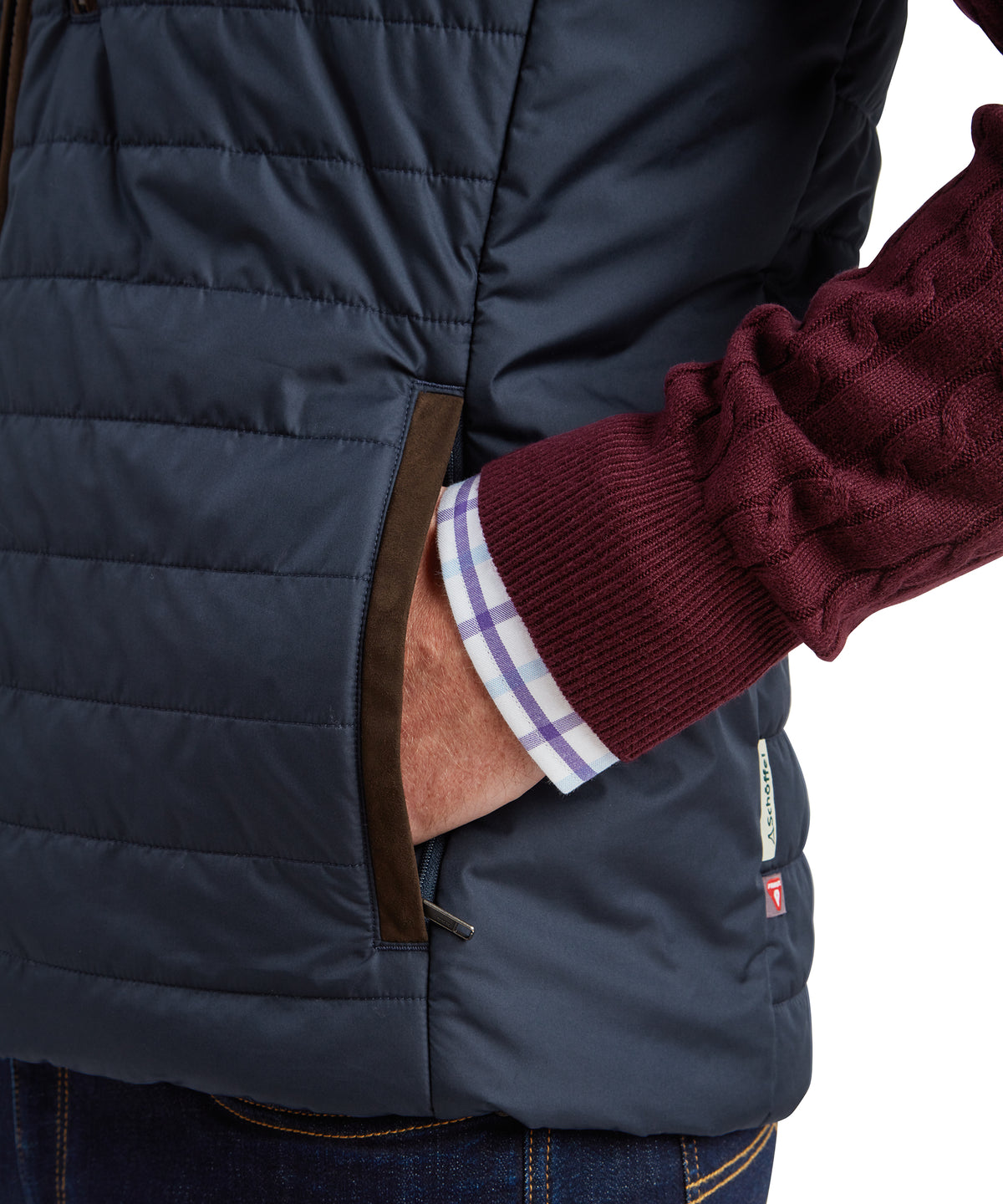 Navy blue quilted brora gilet with brown leather trim and small brand tag on the side