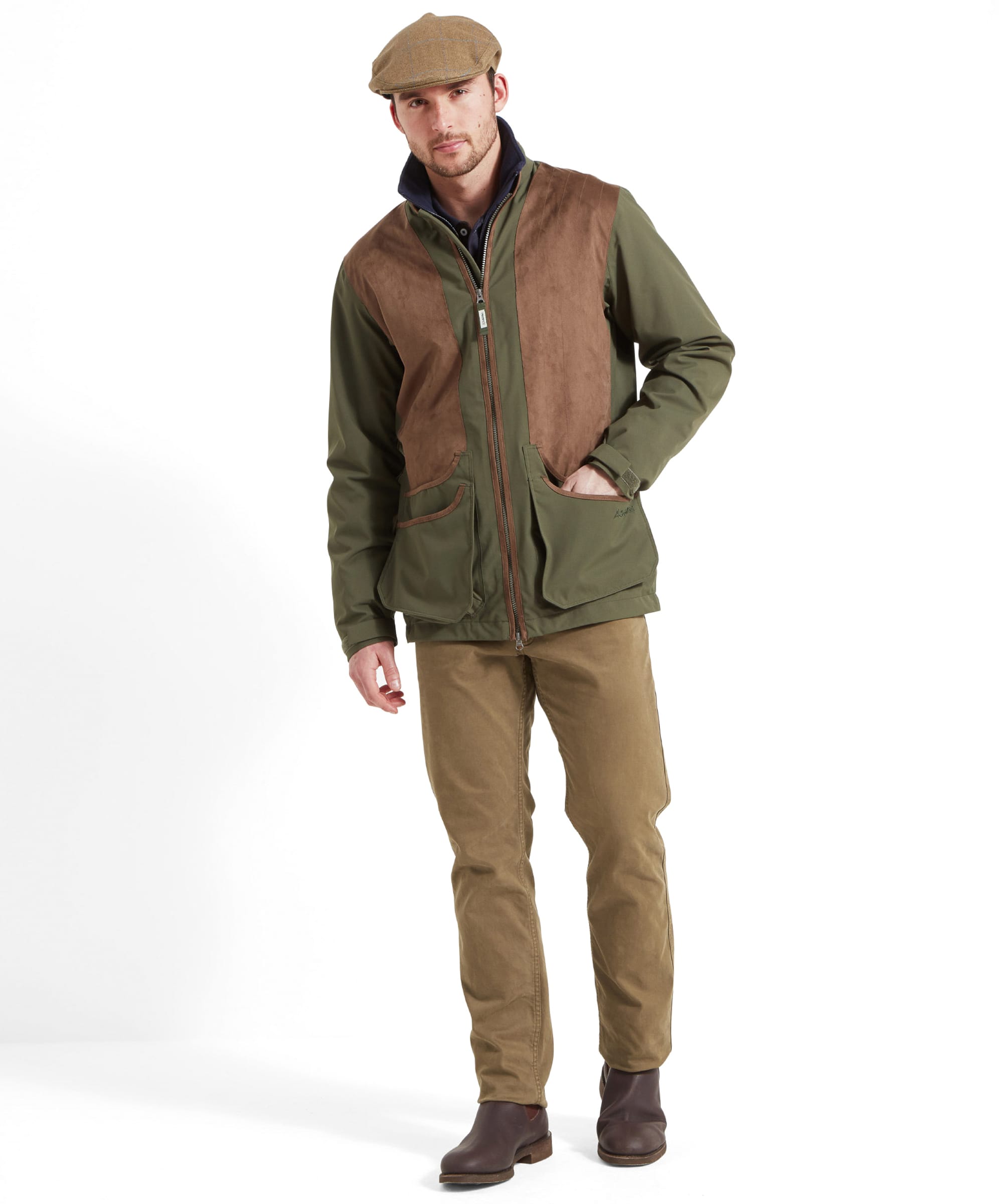 Schöffel Men's Grimsthorpe Clay Shooting Jacket in Green — full-length front view styled with khaki trousers and brown leather Chelsea boots, worn with a tweed flat cap