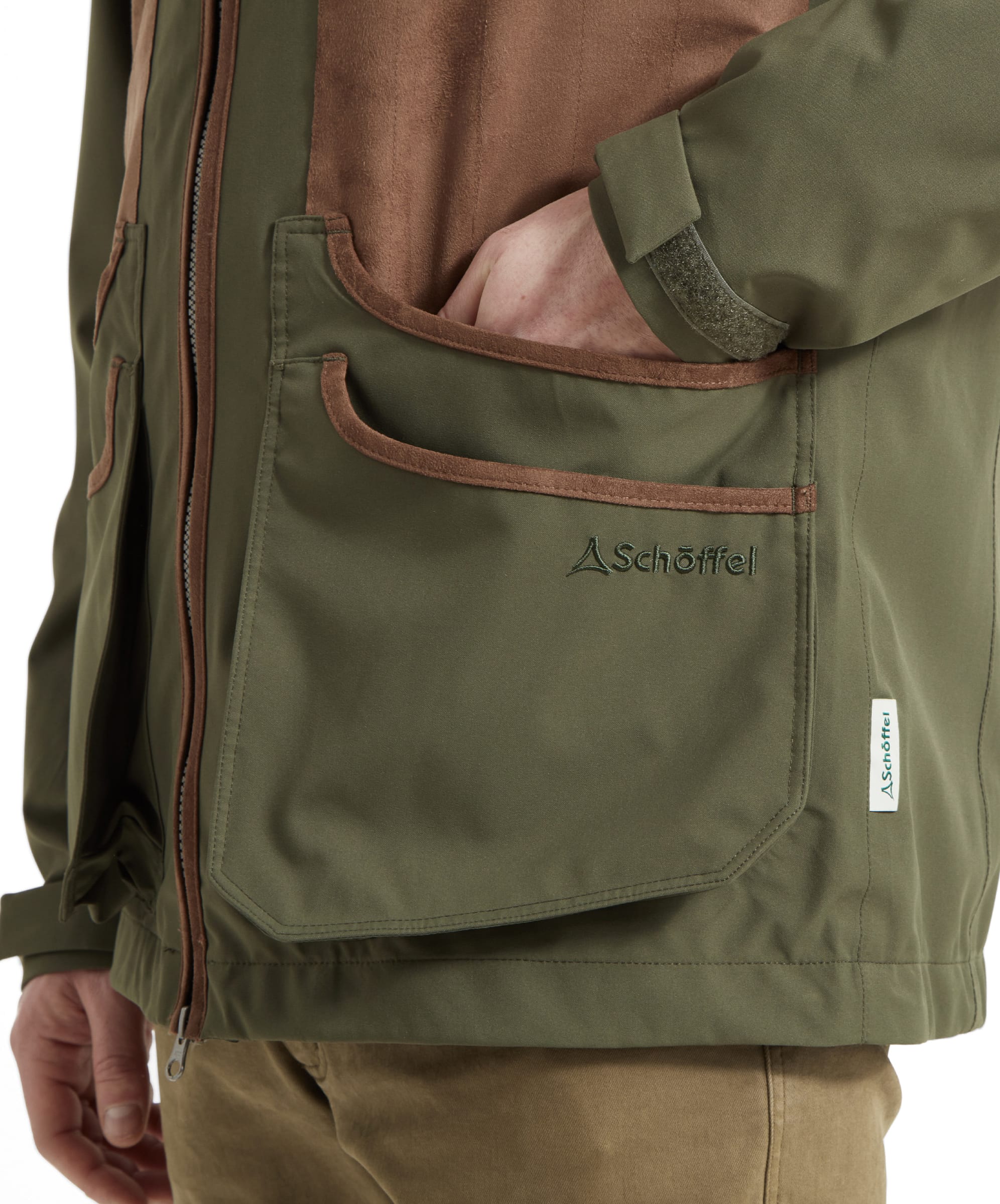Schöffel Men's Grimsthorpe Clay Shooting Jacket in Green — close-up of deep cartridge pocket with suede trim, Schöffel embroidered branding and woven label detail