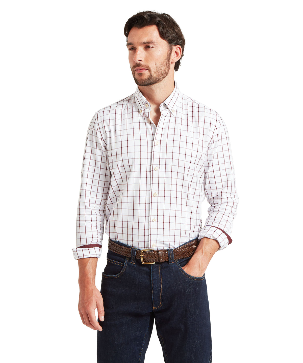 A man wearing a white long-sleeve button-down shirt with a subtle red windowpane pattern.