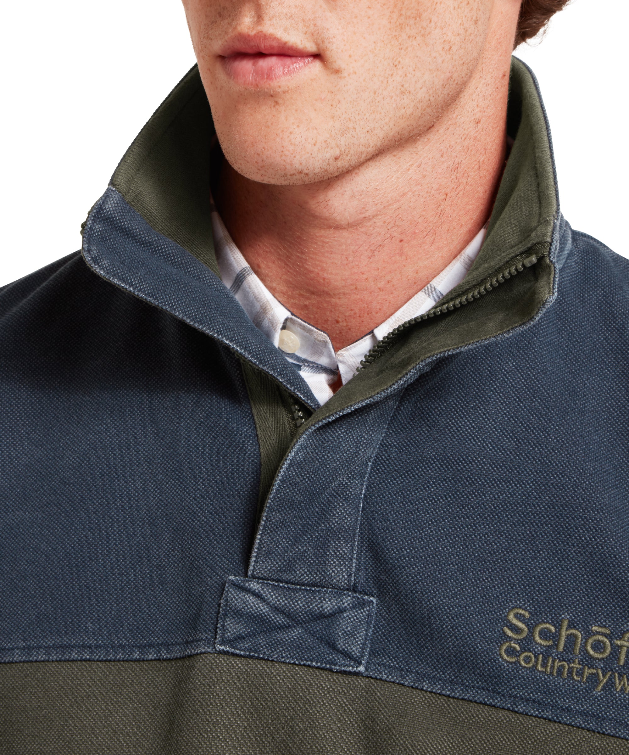 Close-up of a person wearing a navy blue and green sweatshirt with 'Schöffel Countrywear' branding.