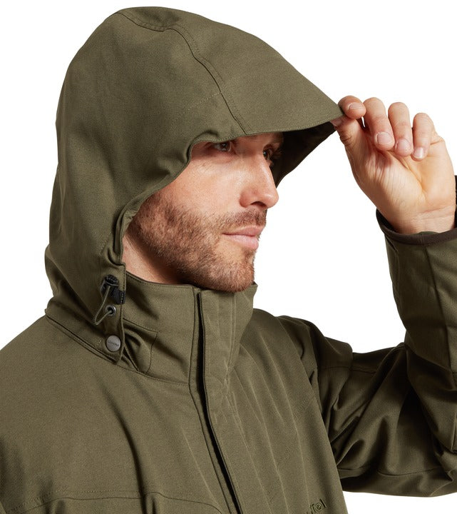 Schöffel Ptarmigan Evo coat in green, man adjusting hood with drawcord toggle and high collar detail