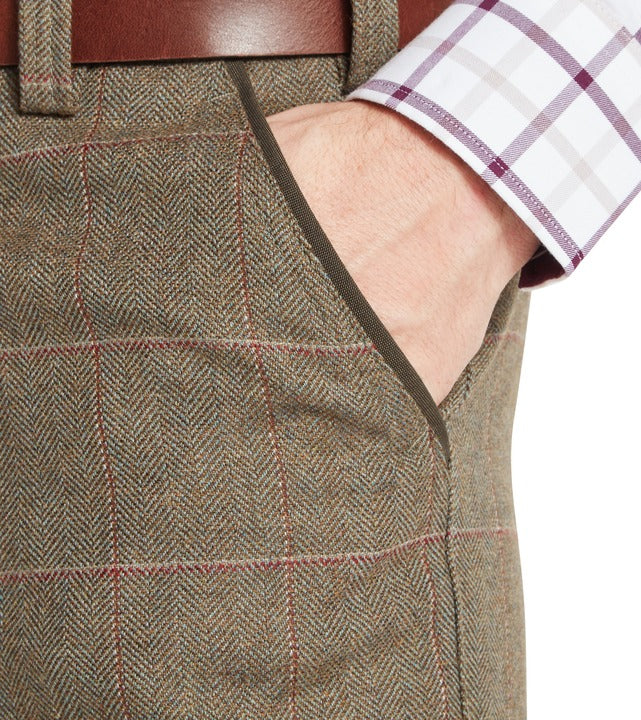 Schöffel Ptarmigan tweed plus twos in Lochlane tweed, close-up of herringbone check fabric with waistband and pocket detail, styled with leather belt