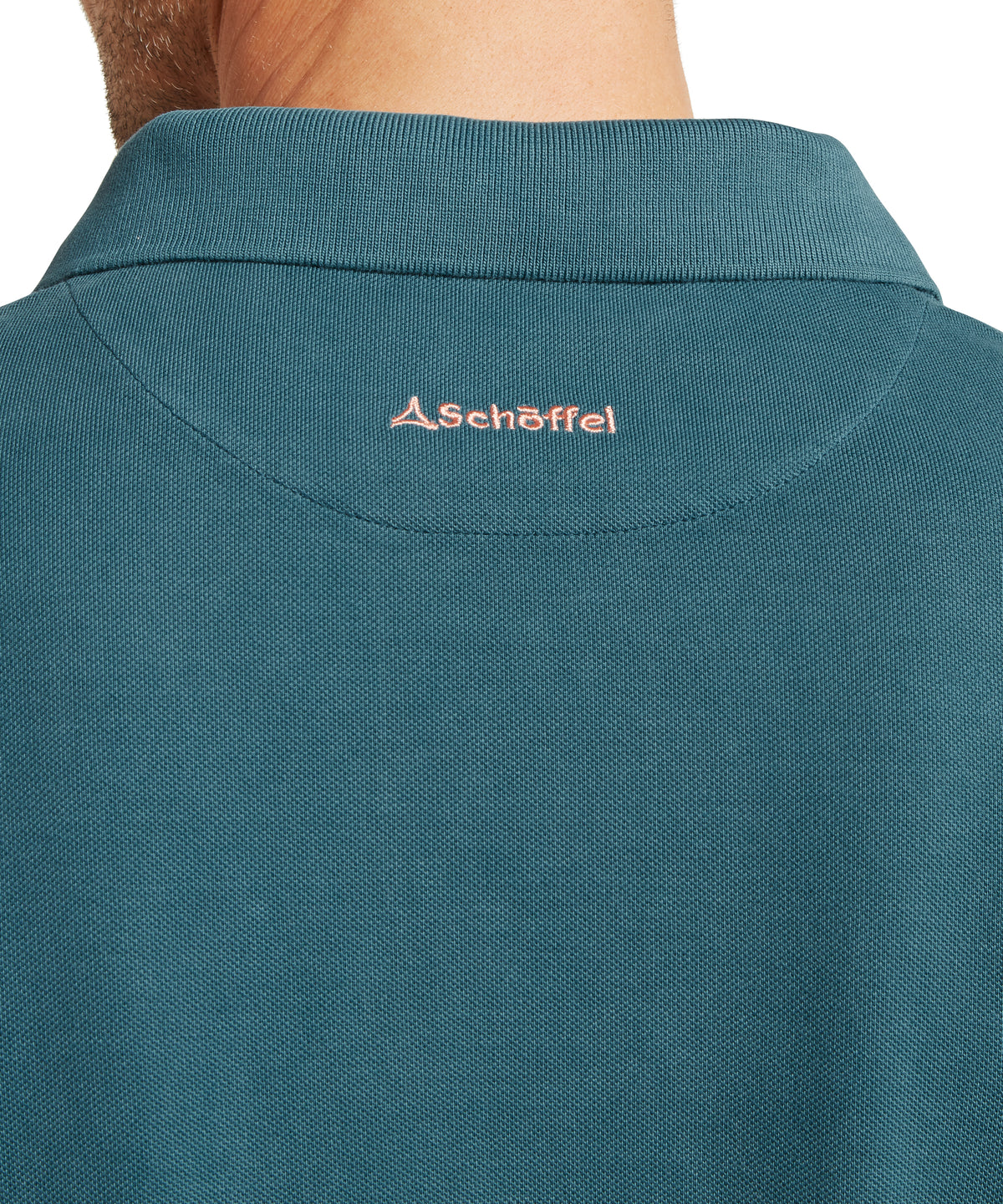 Schöffel's St Ives Garment Dyed Polo Shirt in Blue, on model, pink embroidered brand logo