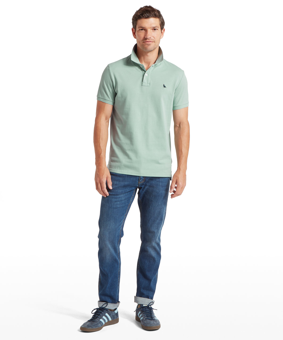 Man wearing light green st ives polo shirt in surf blue with a small black chest logo