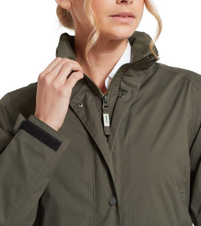 Close-up of Schöffel Women's Edith Jacket in dark olive green, showing the zip fastening, snap-button placket, cuff adjustment and branded zip pull