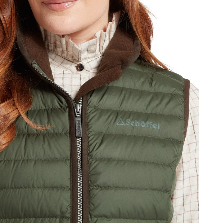 Green puffer gilet with brown collar and zipper, featuring the Schöffel logo, worn on a model.