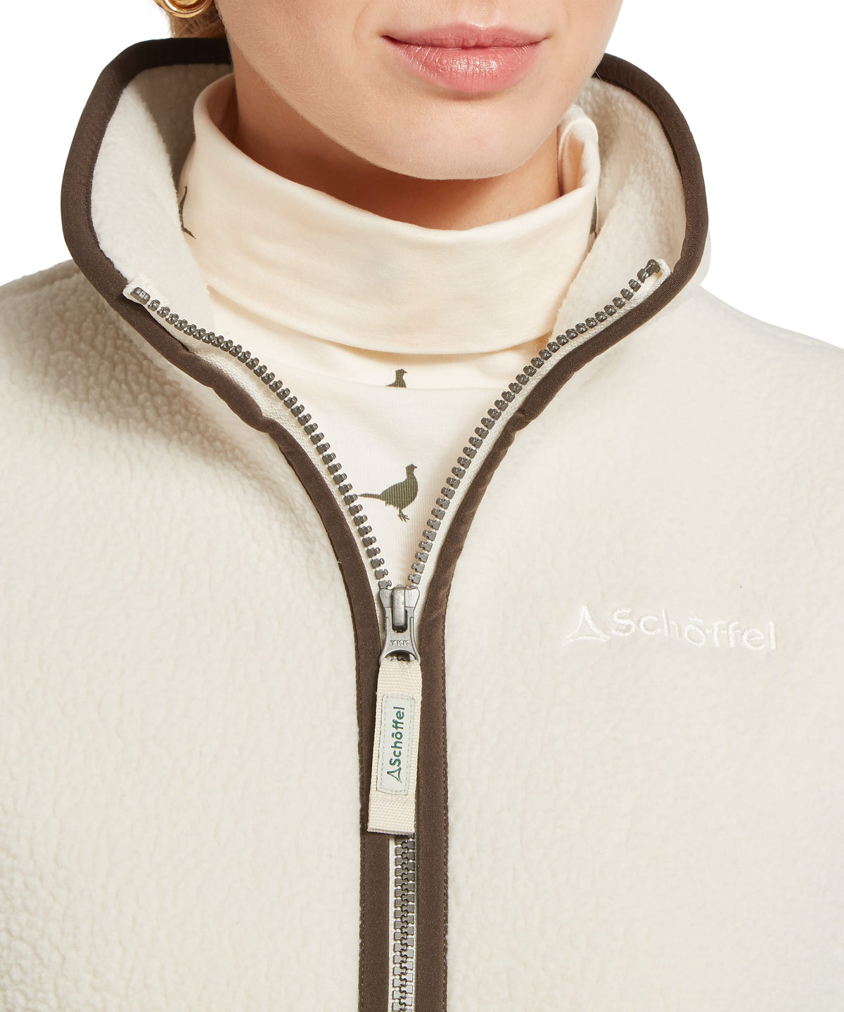 Lyndon Retro fleece gilet in soft white with cream aschaffel fleece and brown trim featuring a bird