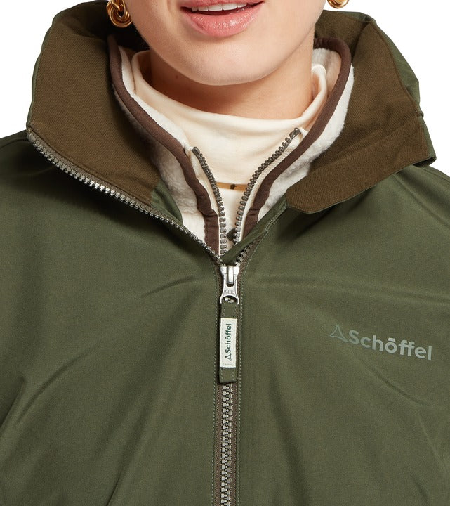 Schöffel Manton women's lightweight jacket in green, close-up of fleece-lined collar and full-length zip with branded pull tag and embroidered logo