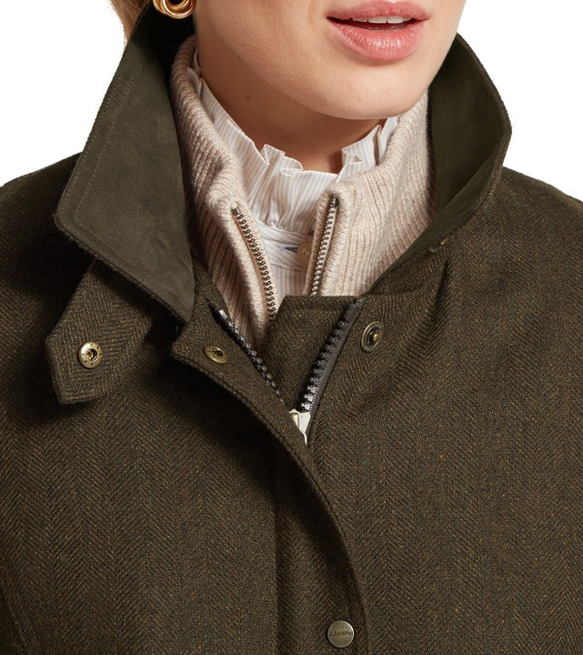 Schöffel Murra tweed coat in brown, close-up of herringbone check fabric with popper and zip fastening, worn over knit jumper and blouse