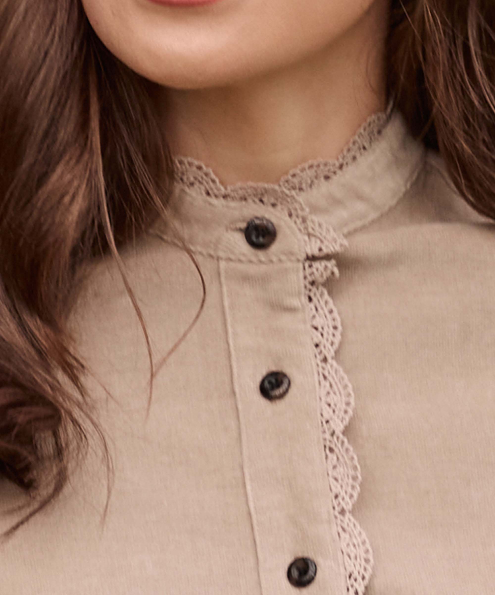 Close-up of a taupe corduroy shirt collar featuring scalloped lace trim and horn-effect buttons, Schöffel Country craftsmanship