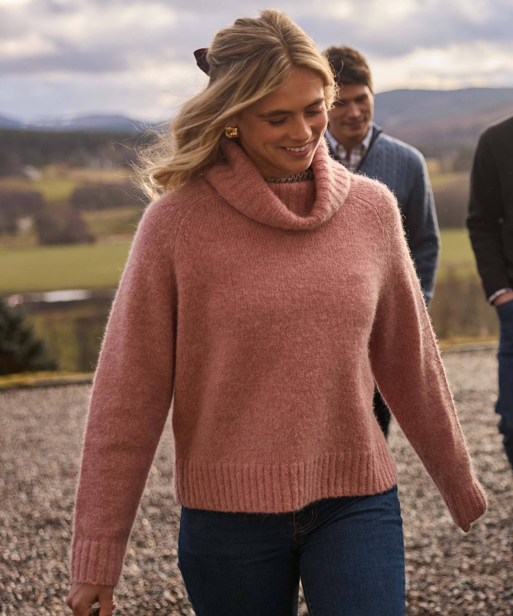 Woman smiling outdoors in a dusky pink cowl neck jumper, a cosy autumn knit from Schöffel Country