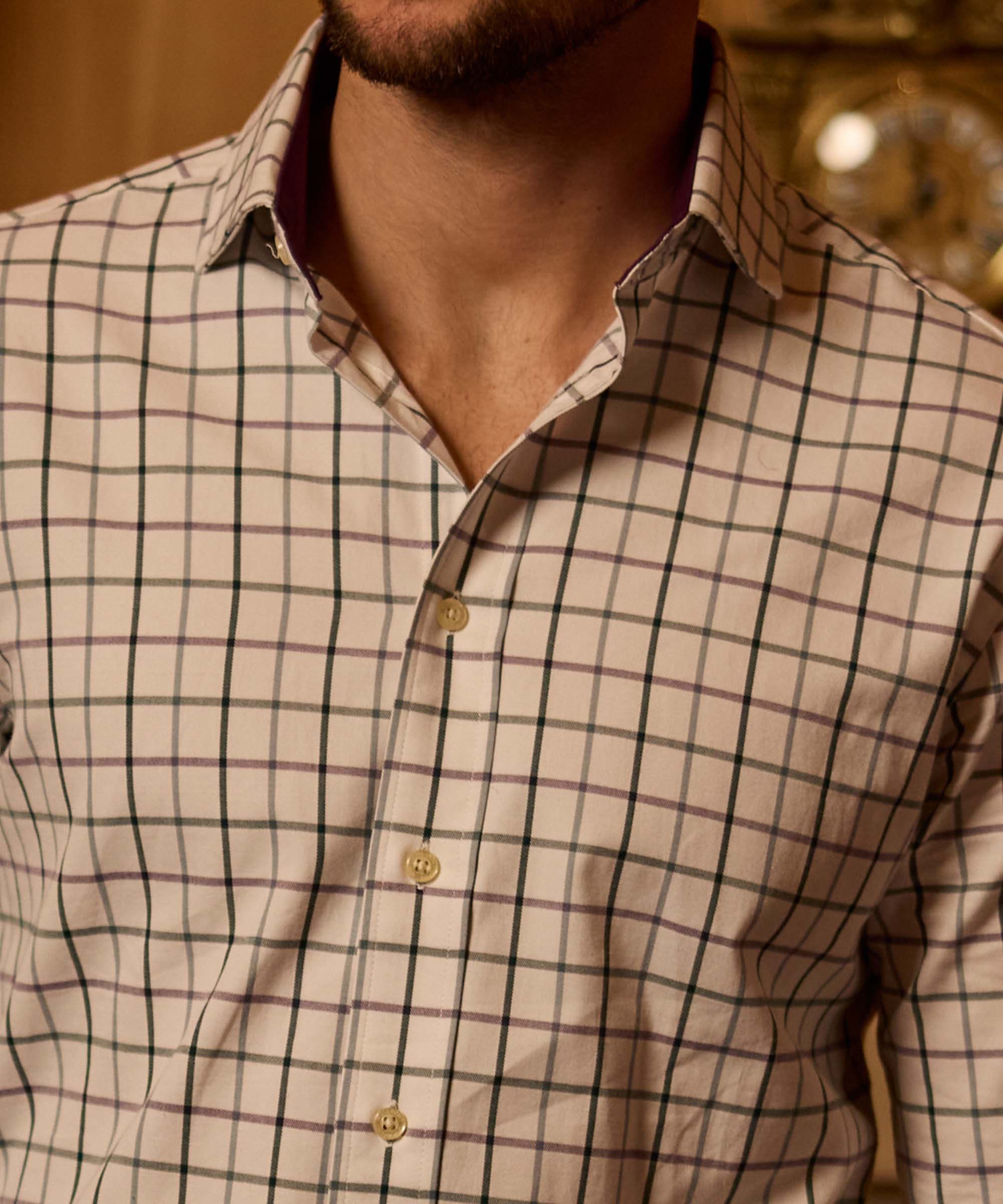 Close-up of a cream check shirt collar, showing the contrasting burgundy trim detail