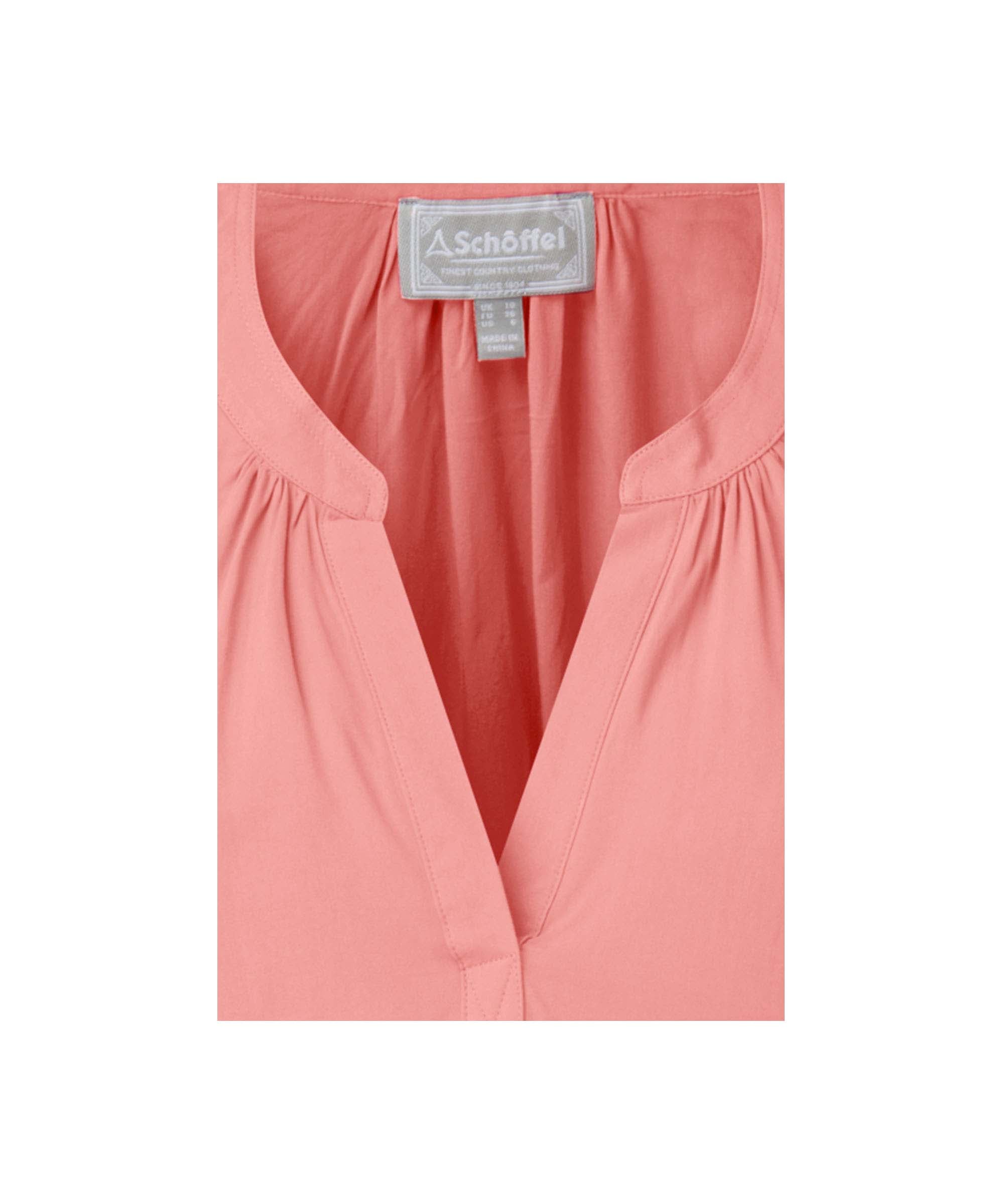 Close up of a pink blouse, showcasing the neckline