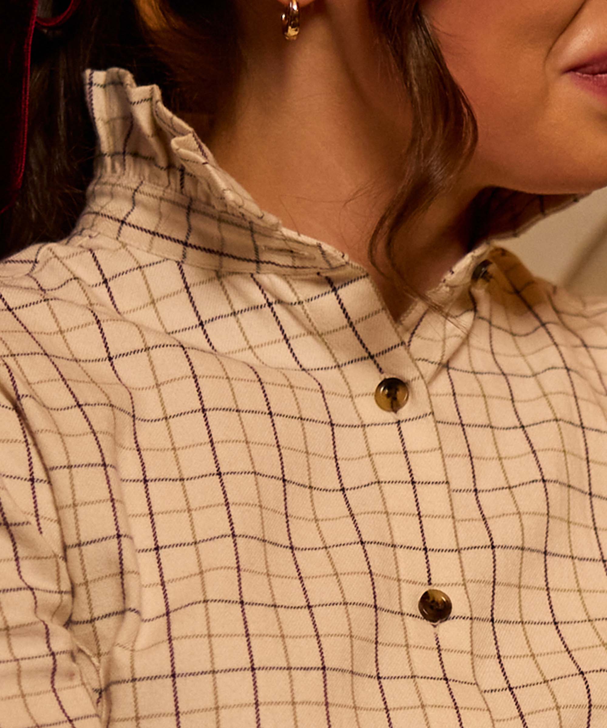 Close-up of the ruffle collar and tortoiseshell buttons on Schöffel Country's ivory windowpane check shirt